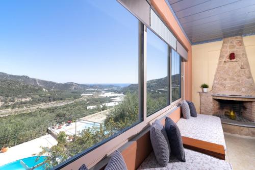 a room with a large window with a fireplace and a view at Sarakinas Residences in Myrtos