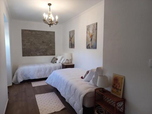a bedroom with two beds and a chandelier at Casa Manel d'Anita in Alge