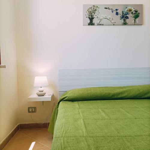 a bedroom with a green bed with a green blanket at Villa Zaira in Baia Verde