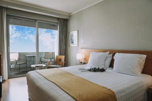 a bedroom with a bed with a view of a balcony at The Athenian Callirhoe Exclusive Hotel in Athens