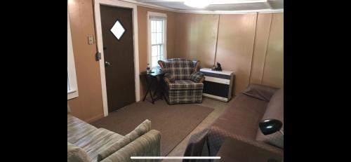 a living room with a couch and a chair at Cute Little Cabin (Near the Nantahala River) in Topton