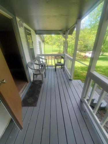 a porch with a table and chairs on it at Cute Little Cabin (Near the Nantahala River) in Topton