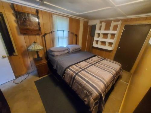 a bedroom with a bed and a lamp in it at Cute Little Cabin (Near the Nantahala River) in Topton