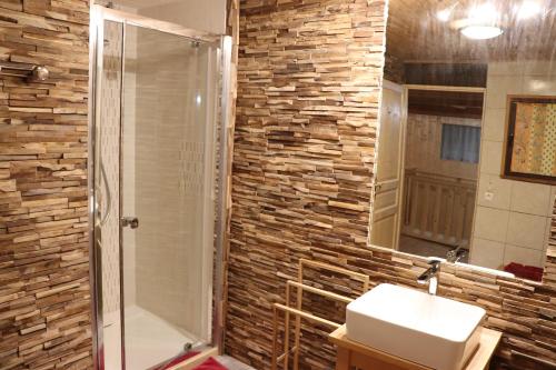 uma casa de banho com um lavatório e um chuveiro em GITE DES FUVES em Luisans