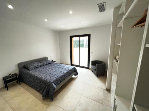 une chambre avec un lit et une chaise dedans dans l'établissement Villa Moderne avec Piscine et Parking à Mouans-Sartoux, à Mouans-Sartoux