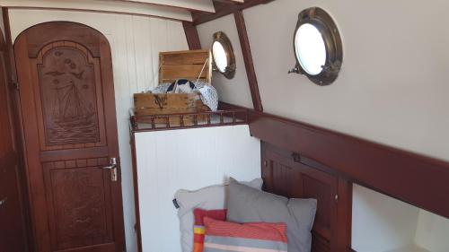 a room with a door and a shelf with pillows at Zeilklipper Fort Zeelandia in Kamperland