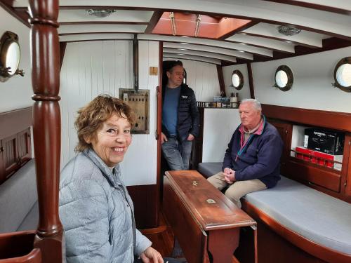 a woman and two people sitting in a boat at Zeilklipper Fort Zeelandia in Kamperland