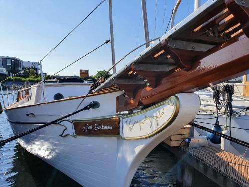a boat is docked at a dock in the water at Zeilklipper Fort Zeelandia in Kamperland