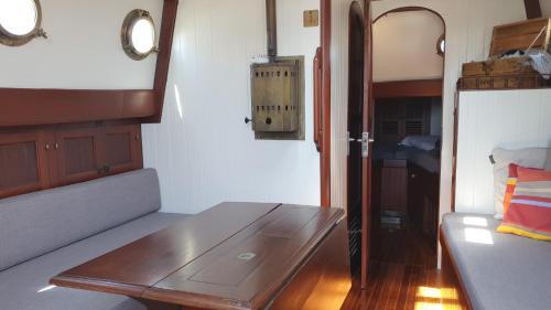 a living room with a couch and a wooden table at Zeilklipper Fort Zeelandia in Kamperland
