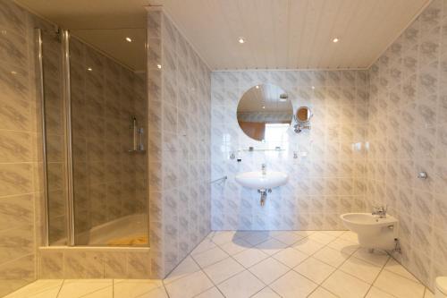 a bathroom with a shower and a sink and a toilet at Hotel Wald und See in Heringsdorf