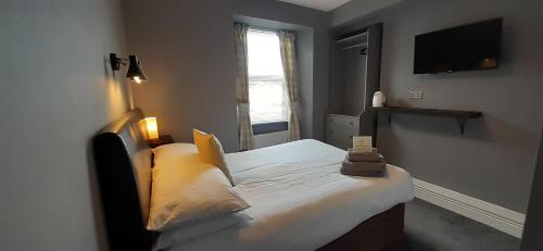 a small bedroom with a bed and a television at Brook House ― Free on-site car park in Windermere