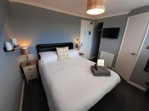 a bedroom with a large bed with a towel on it at Brook House ― Free on-site car park in Windermere