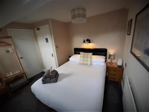 a bedroom with a large white bed with a purse on it at Brook House ― Free on-site car park in Windermere