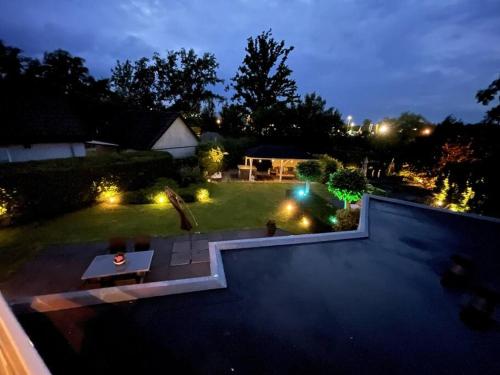 uitzicht op een achtertuin 's nachts met verlichting bij Luxury villa with private Sauna and Jacuzzi in Holland in Drachten