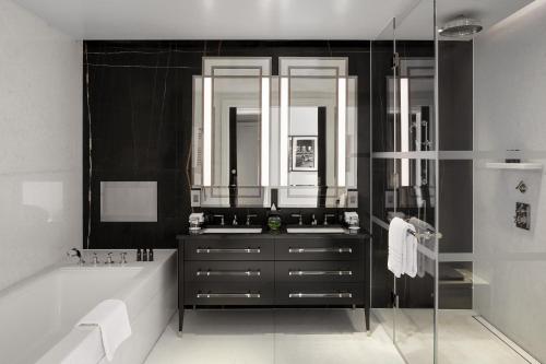 a bathroom with a sink and a tub and a mirror at Four Seasons Hotel London at Tower Bridge in London