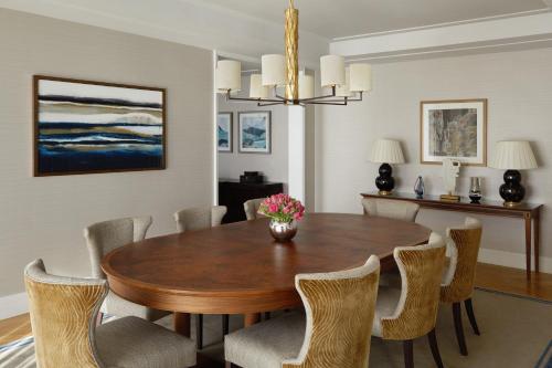 a dining room with a wooden table and chairs at Four Seasons Hotel London at Tower Bridge in London