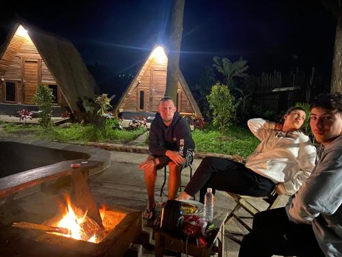 a group of people sitting around a fire pit at Triangle House and hot spring in Kintamani
