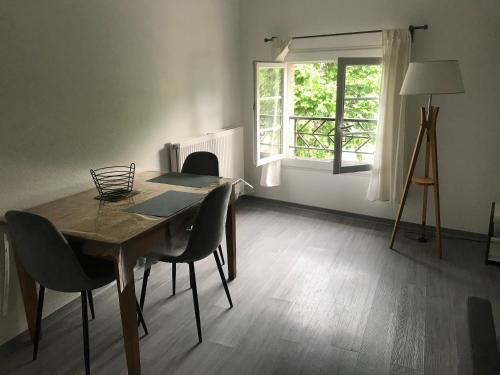 ein Esszimmer mit einem Tisch, Stühlen und einem Fenster in der Unterkunft Foix cœur de ville in Foix