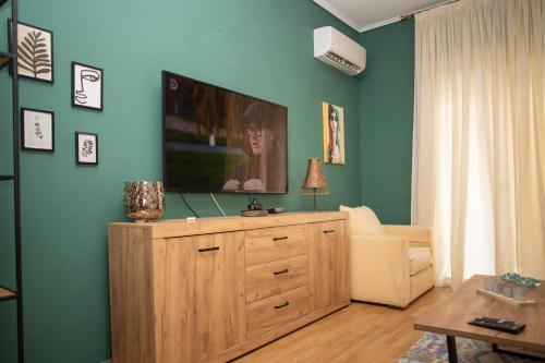 a living room with a television on a wooden dresser at Santa Marina in Ioannina