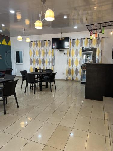 a dining room with tables and chairs in a restaurant at Sky Inn Hotel in Freetown