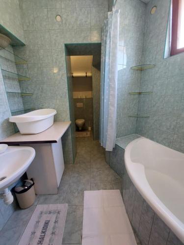 a bathroom with a tub and a toilet and a sink at CsaládBarát Vendéglak Szegedi Magánszálláshely 9 fő részére, nagycsaládok és baráti társaságok részére in Szeged