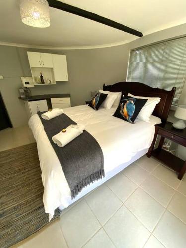 een slaapkamer met een groot wit bed met kussens bij Pretoria Country Club- Kingfisher Hut in Pretoria