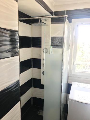 La salle de bains est pourvue de murs à rayures noir et blanc et d'une douche. dans l'établissement NICE PARC PHOENIX, à Nice