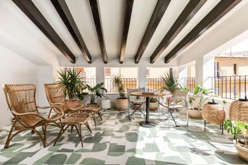 a room with chairs and tables and potted plants at Concepcio by Nobis, Palma, a Member of Design Hotels in Palma de Mallorca