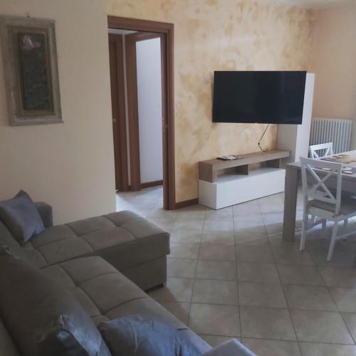 a living room with a couch and a flat screen tv at CasaMG in Ravenna