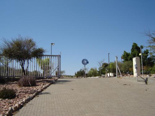 an empty parking lot with a fence and trees at Rooisand Desert Ranch in Chausib