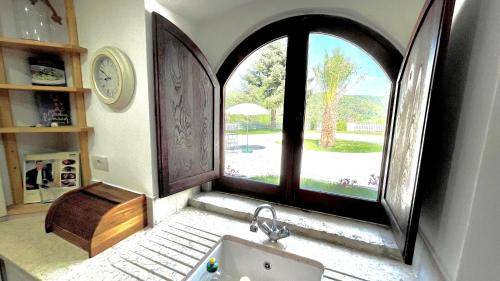 a bathroom with a sink and a large window at Novecento Country House in Vieste