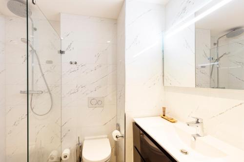 a bathroom with a shower and a toilet and a sink at Boutique Apartments Amsterdam in Amsterdam