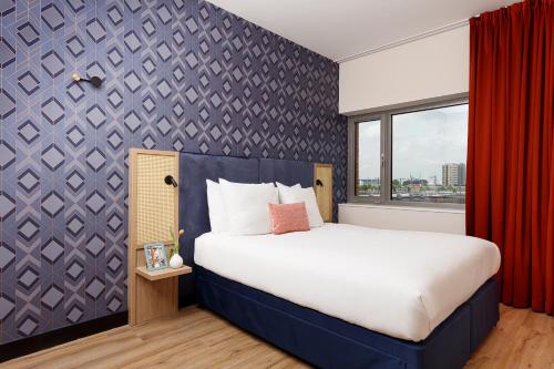 a bedroom with a large bed and a red curtain at Boutique Apartments Amsterdam in Amsterdam