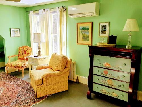 a green room with a chair and a dresser at Belfry Inn and Bistro in Sandwich