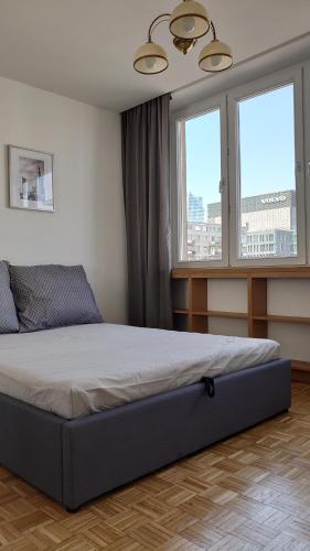 1 dormitorio con 1 cama en una habitación con ventanas en WSPÓLNA en Varsovia