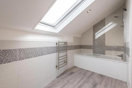 a bathroom with a bath tub and a skylight at The Cavern Quarter Aparthotel by UStay in Liverpool