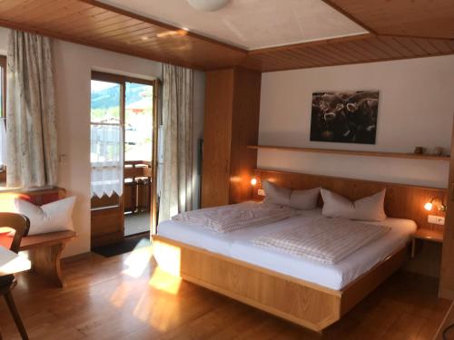 a bedroom with a bed and a large window at Haus Petra in Oberjoch