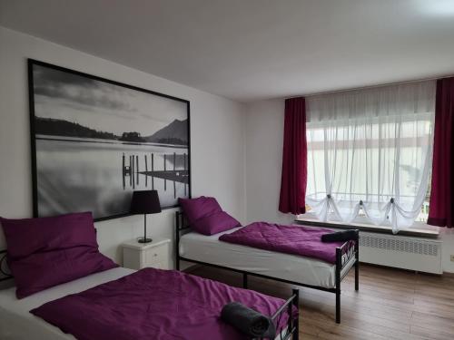 two beds in a room with purple pillows at Relax City Apartments in Kehl am Rhein