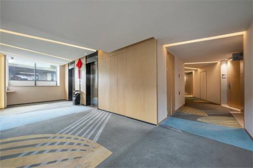 an empty hallway of a building with a large window at Holiday Inn Express Emei Mountain by IHG in Emeishan