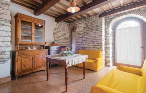 a living room with a table and a yellow chair at Casa Ssilvestro in Borghetto di Fenigli