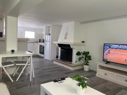 un salon avec une télévision et une cuisine dans l'établissement Appartement cosy en résidence, à Martigues