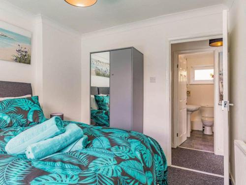 a bedroom with a bed with blue sheets and a bathroom at Lovely Apartment 3 King-size beds in Torquay