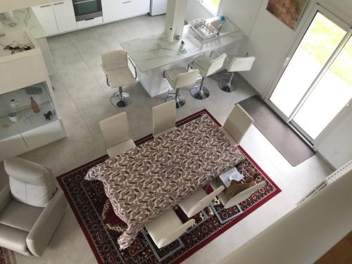 vista sul soffitto di un soggiorno con tavolo e sedie di Maison moderne 8 personnes, jardin, parkings, fibre THD, plage 5 min a Vannes