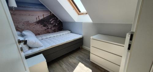 a small room with a bed in a attic at Apartamenty Wrzosowa in Dębki