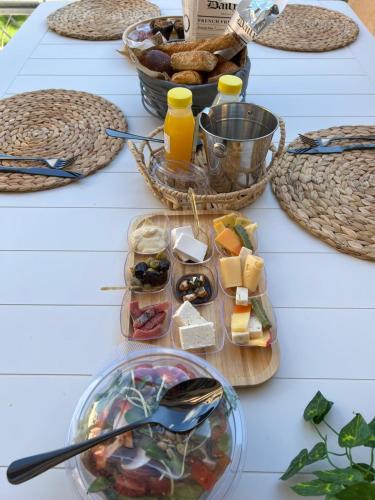 a table topped with plates of food and baskets of food at lasuita-exclusive suites ceserea-luxury suite in Caesarea