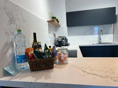a kitchen counter with a basket of food and a bottle of water at lasuita-exclusive suites ceserea-luxury suite in Caesarea