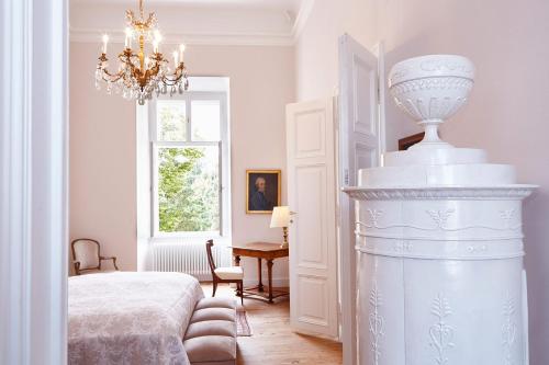 um quarto branco com uma cama e um lustre em Exklusiver, privater Schlosstrakt im Schloss Horn em Horn