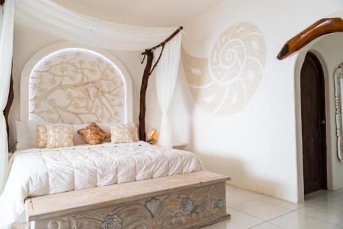 a bedroom with a bed with a canopy at Hotel Pasión de Luna in Puerto Ángel