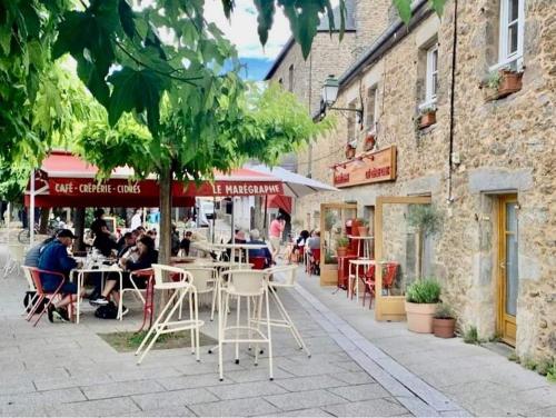 a group of people sitting at tables on a city street at Appartement Cosy 1 chambre pour 2 pers - rénové - terrasse - parking in Dinard