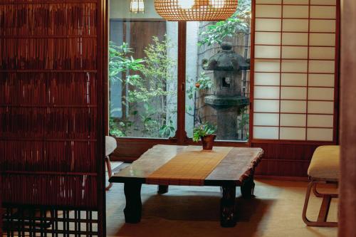 a room with a table and a window with a fountain at 一棟貸し町家Keiko in Kyoto